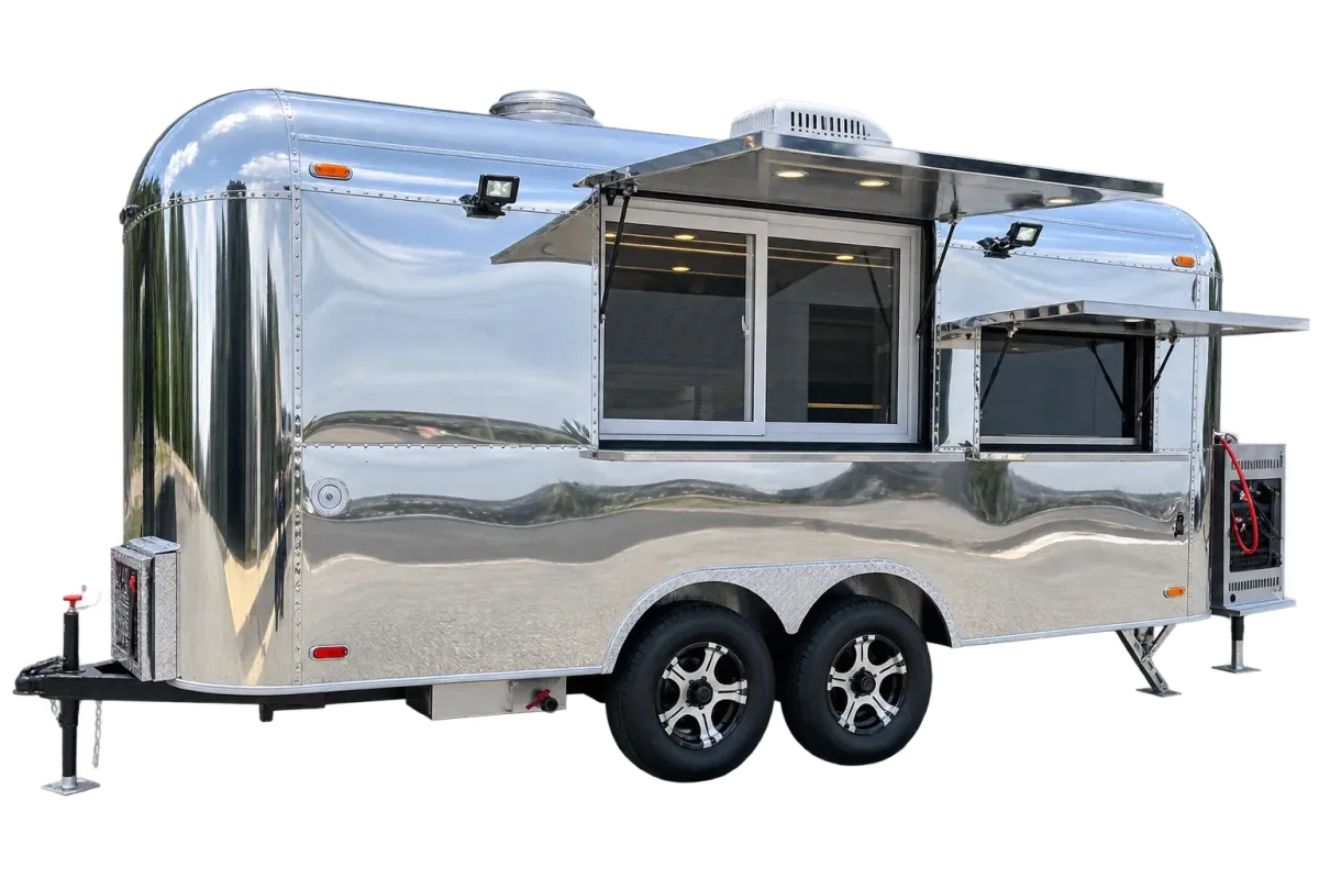 Polished aluminum airstream-style food trailer with the serving hatch open and tandem axles